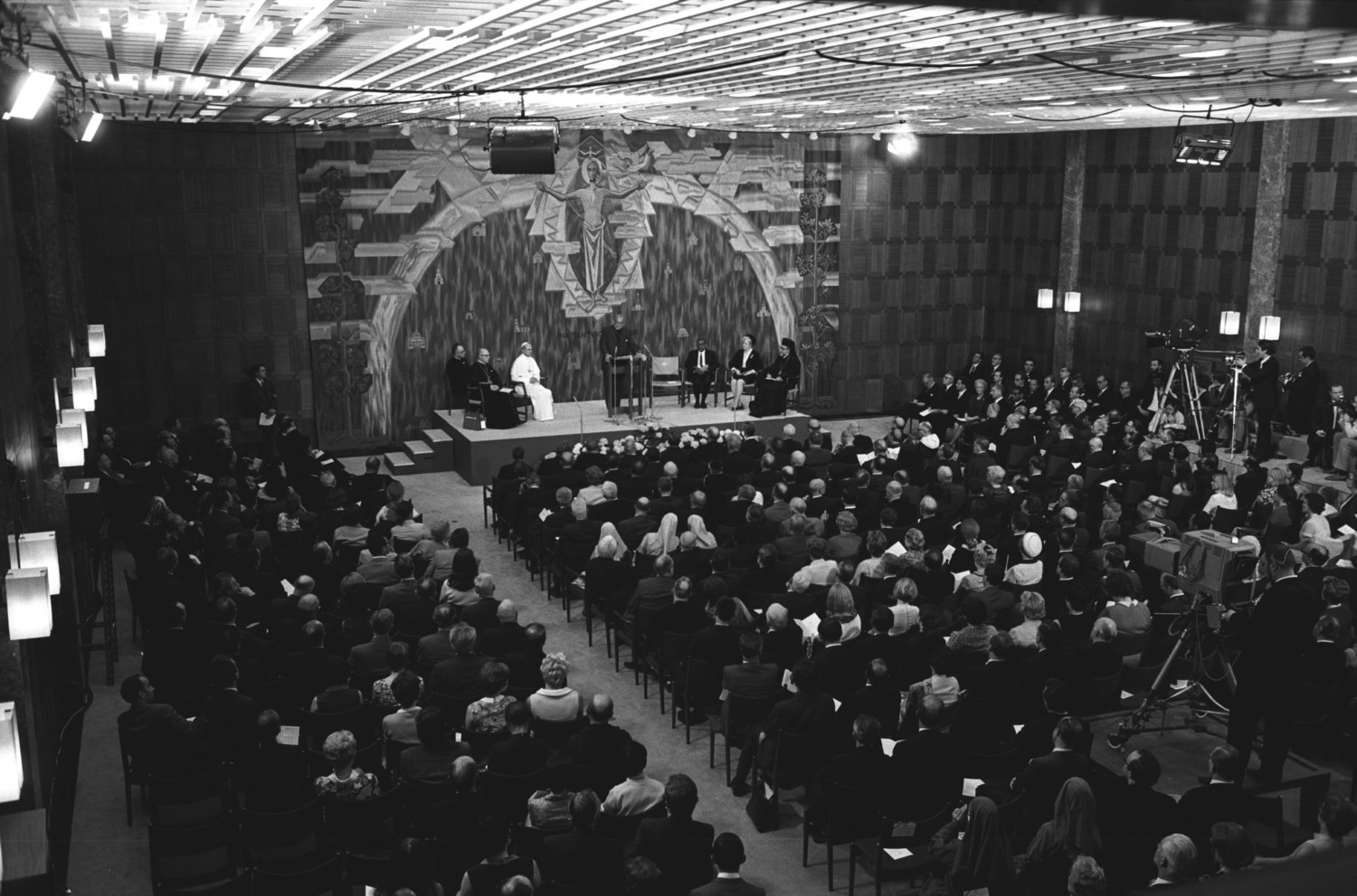Blessed Pope Paul VI is seated as Eugene C. Blake, general secretary of the World Council of Churches, gives a speech during the Pope’s visit to the WCC in Geneva, June 10, 1969. Seated to the left on the stage are: Father Pasquale Macchi, personal secretary to the Pope, and Cardinal Johannes Willebrands, president of the Pontifical Council for Promoting Christian Unity. Pope Francis is scheduled to attend an ecumenical prayer service and meeting at the WCC during a one-day visit to Geneva June 21.
